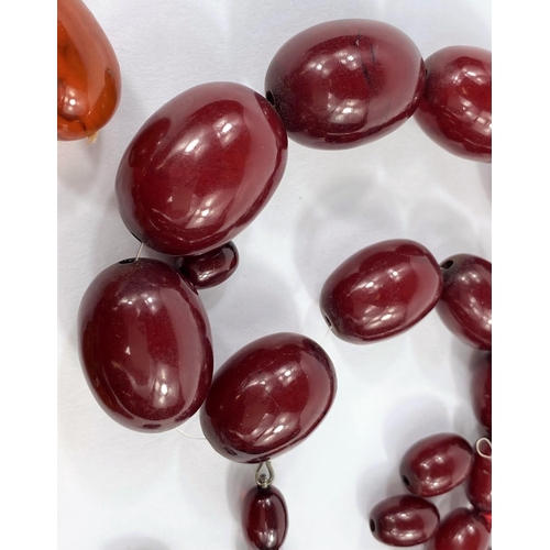 660 - A Bakelite cherry amber necklace of graduating oval beads, largest bead length 2.8 mm approx; a neck... 