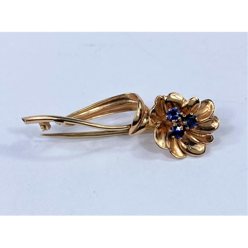 674 - A 9 carat gold flower stem brooch set 3 blue stones, 5.3 gm