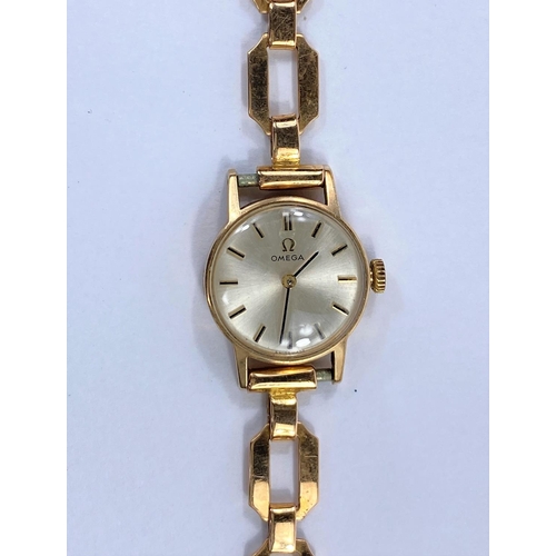 697 - A ladies 9 carat hallmarked gold wristwatch by Omega on yellow metal bracelet, stamped '18c', net we... 