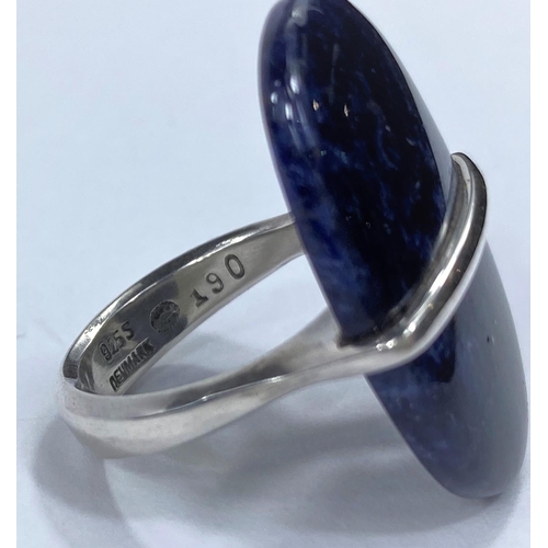 725 - Georg Jensen, an open shank silver ring with a large oval cabochon solitaire stone, held by central ... 