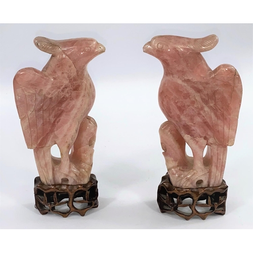 81 - A 20th century Chinese pair of carved rose quartz figures of mythical birds, on hardwood bases, heig... 