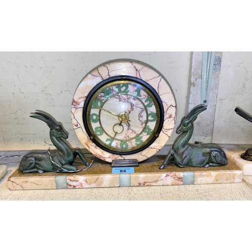 84 - An Art Deco style marble mantle clock with circular central clock with two spelter antelope to eithe... 
