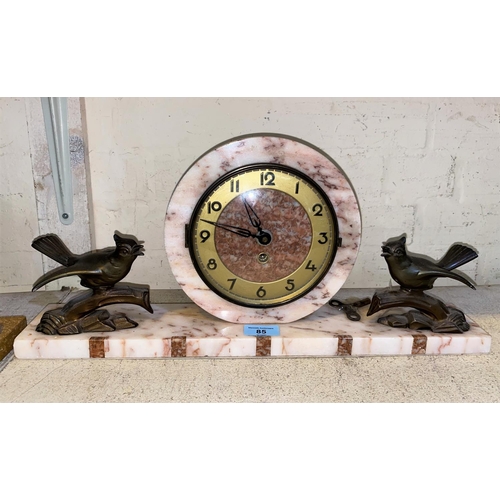 85 - An Art Deco style marble mantle clock with circular central lock with two spelter birds on branches ... 