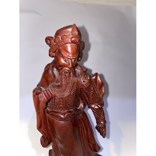 427 - A Chinese carved wooden figure of a sage with bead eyes to face and shoulder, height 30cm