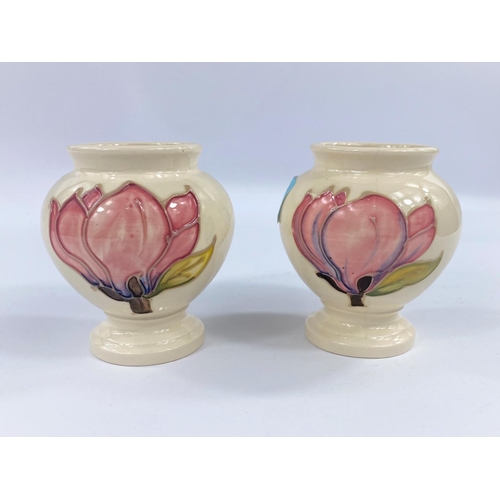 473 - A pair of small Moorcroft baluster vases, magnolia pattern on cream ground. Height 9cm