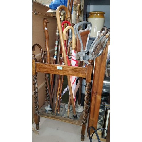 13 - A 1920's 2 division stick stand with barley twist supports containing a selection of walking sticks ... 