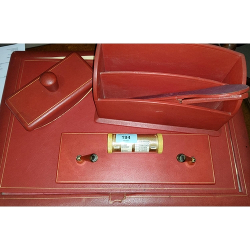 194 - An early / mid 20th century red leather desk set including blotter, letter rack, pen stand, perpetua... 