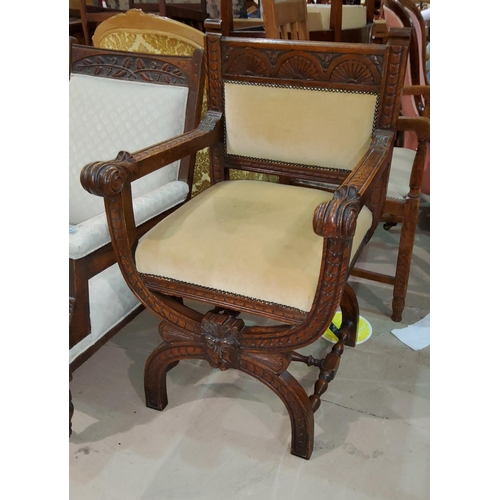 823 - A late Victorian carved oak 'X' framed armchair in cream dralon