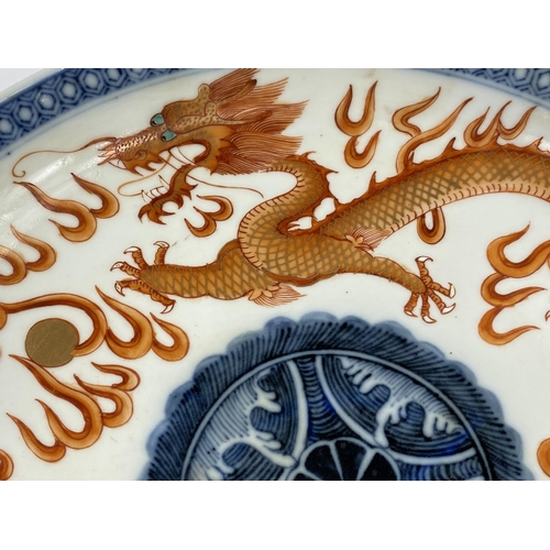 439 - A Chinese ceramic dish, decorated with dragon and mythical
bird circling the centre of the plate, wi... 