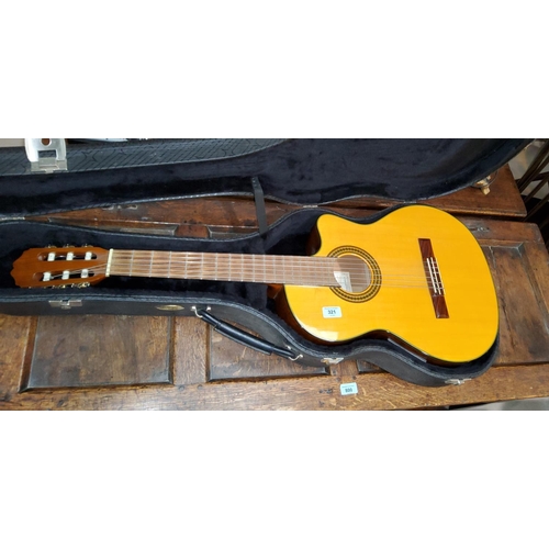 321 - A cut away classical guitar by Takamine, with hard carry case - The instrument seems in good order a... 