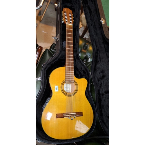 322 - A cut away classical guitar by Takamine, with hard carry case - The electrics will require some atte... 