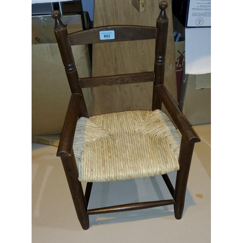 802 - A child's 19th century style armchair with rush seat; an Edwardian rocking chair with spindle back
