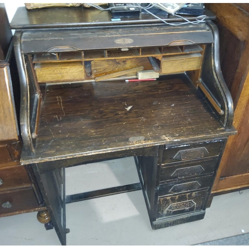 833 - An early 20th century single pedestal desk with 'S' scroll roll top, fitted interior and 4 drawers
