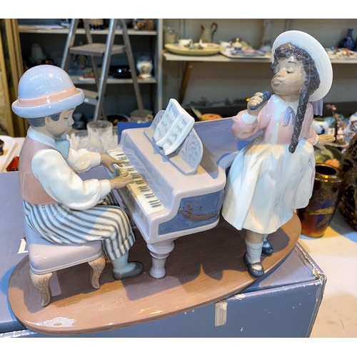 471 - A boxed Lladro group playing the piano, girl singing,  
No/5930 (large star impact to piano & hairli... 