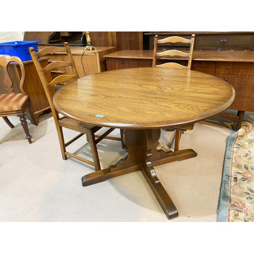 797b - An Ercol medium oak dining suite comprising single pedestal table with circular extending top and sp... 