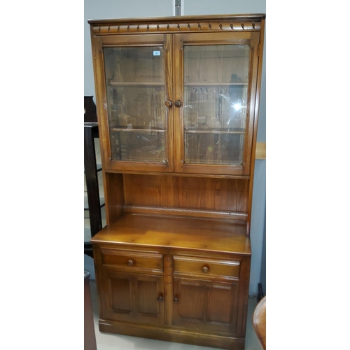 797a - An Ercol medium oak wall unit with double glazed over 2 linen fold doors and 2 drawers