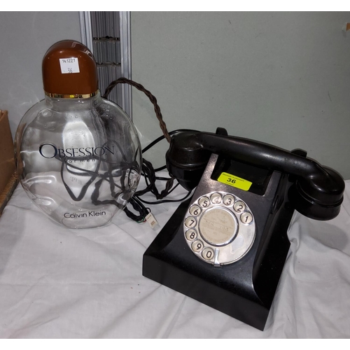36 - A rotary telephone in black bakelite; an 'Obsession' for men display bottle