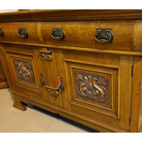 909 - An Edwardian golden oak buffet sideboard with raised back and carved decoration, 2 cupboards and 2 d... 