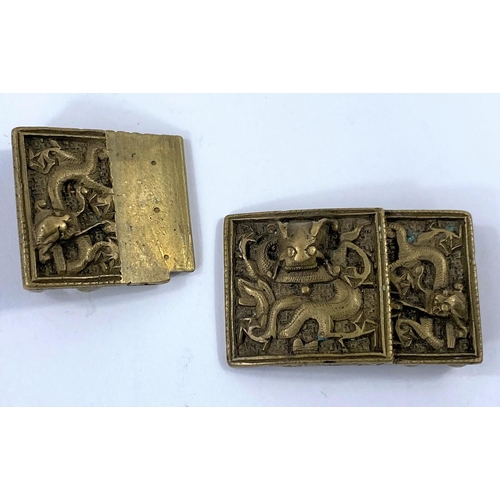 421 - A Chinese brass belt buckle decorated with a dragon, with slip catch and two miniature Chinese brass... 