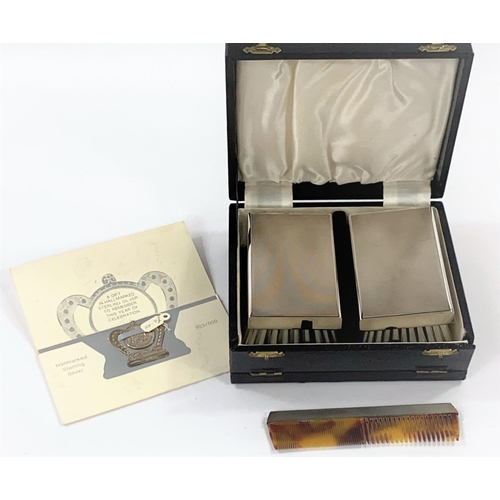 701 - A gent's pair of silver back hairbrushes, with comb, cased; a QEII 1977 souvenir note clip