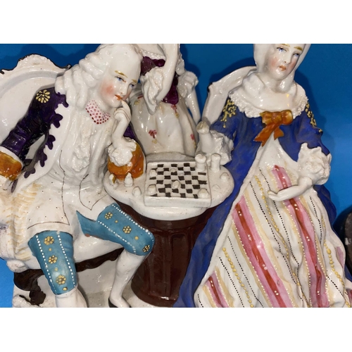 579 - A Dresden style china two bottle ink stand, the cover in the form of figures playing chess, length 7... 