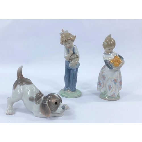 595 - Two Lladro figures - a crouching puppy and a girl with oranges and a Nao figure of a girl with dog, ... 