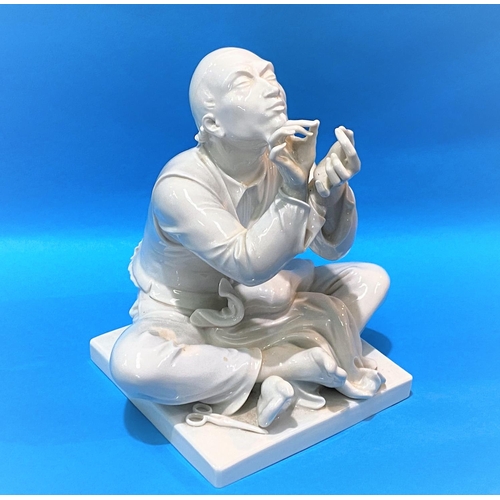599 - A modern Meissen blanc de chine figure of a Chinese man, seated and threading a needle, height 22cm.... 