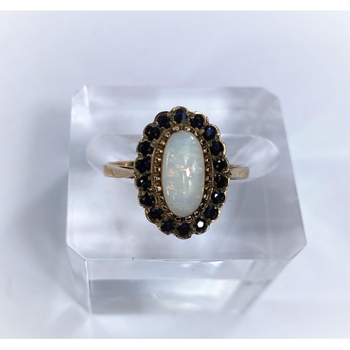 671 - A 9 carat hallmarked gold ring set opal coloured oval stone surrounded by blue stones, 2.4 gm, size ... 
