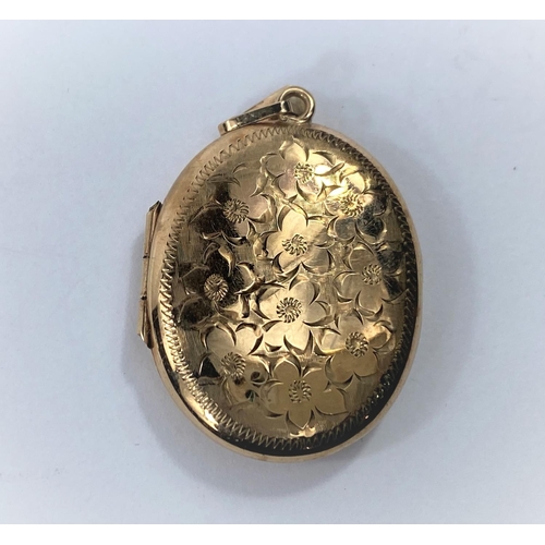 673 - A 9 carat hallmarked gold oval locket with chased flowerhead decoration, 10.6 gm