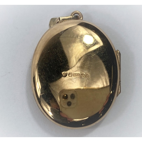 673 - A 9 carat hallmarked gold oval locket with chased flowerhead decoration, 10.6 gm