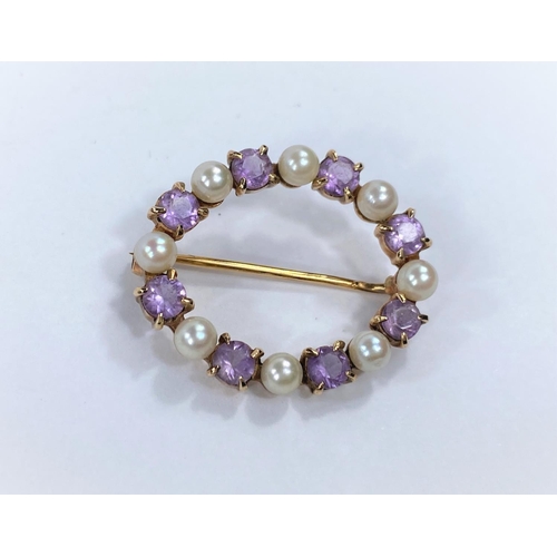 676 - A yellow metal oval brooch set alternating amethyst and seed pearls, stamped '9 ct', 4.5 gm