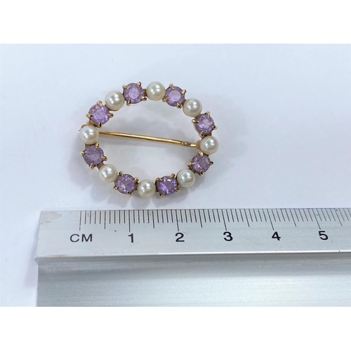 676 - A yellow metal oval brooch set alternating amethyst and seed pearls, stamped '9 ct', 4.5 gm
