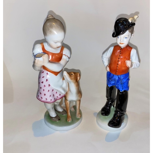 620 - Two Herend Hungarian figures, boy in Alpine hat and boots and girl with dog, heights 22cm and 23cm
