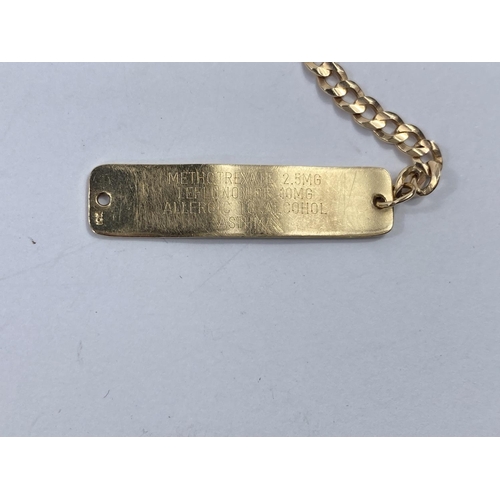 644 - A yellow metal flattened curb link name bracelet with blue enamel fob and safety chain, all stamped ... 