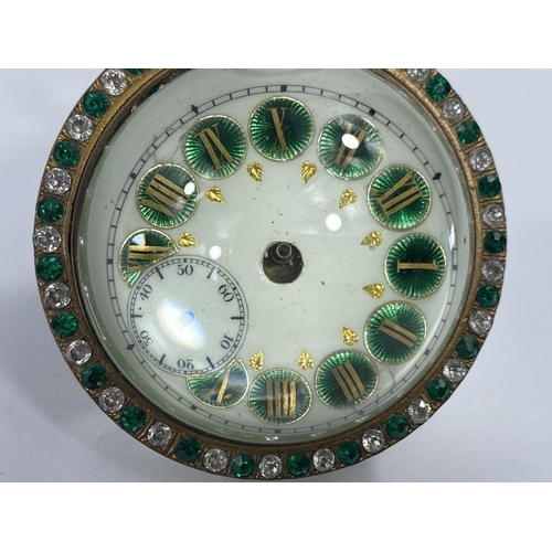 727 - An early 20th century time piece with spherical case set with green and clear stones, with green and... 