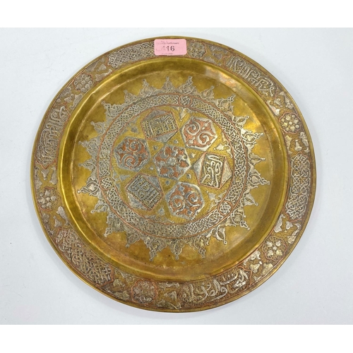 416 - An Islamic silvered copper and brass dish with areas of text and other decoration to the centre and ... 