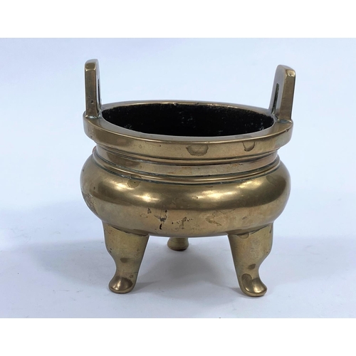 425 - A 19th century Chinese circular brass incense burner on 3 feet with raised squared hoop handles, dia... 