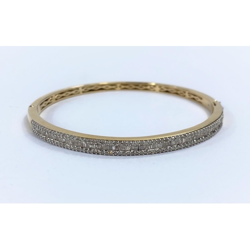 714a - An originally boxed Vermeil gold plate on silver bangle with a row of baguette cut diamonds surround... 