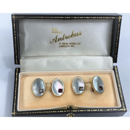 715a - A pair of yellow metal cufflinks with oval mother of pearl insets, diamond and ruby mount to each, i... 