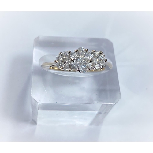 717b - An white metal lady’s dress ring, the shank stamped 18K, set with 3 groups of diamond flowerhead clu... 
