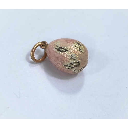 718c - A small pink enamelled Russian style egg pendant / charm in the Faberge manner, stamped to loop A W,... 