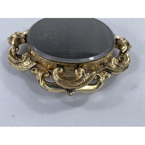 718d -  A yellow metal mourning brooch with dark bevelled glass front and back, length 5.5cm
