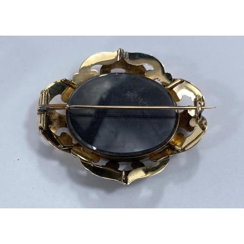 718d -  A yellow metal mourning brooch with dark bevelled glass front and back, length 5.5cm