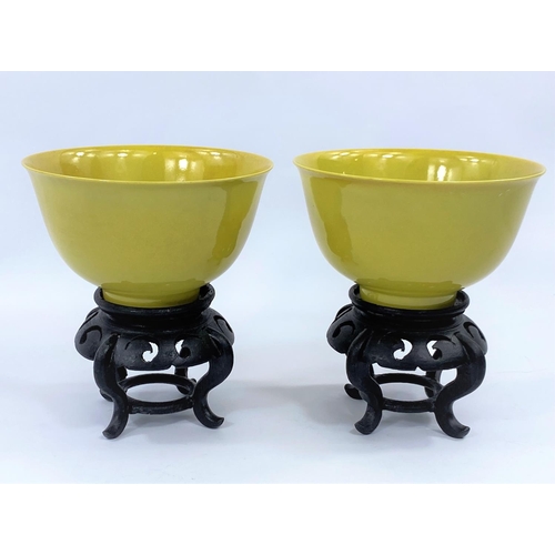 428 - A pair of Chinese yellow glaze rice bowls, on hardwood stands, with seal mark to bases, diameter 12.... 