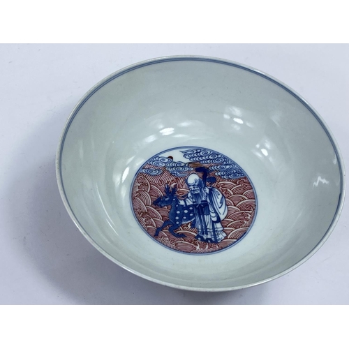 429 - A Chinese ceramic bowl with blue and white figures of sages etc, with detailed red wave decoration t... 
