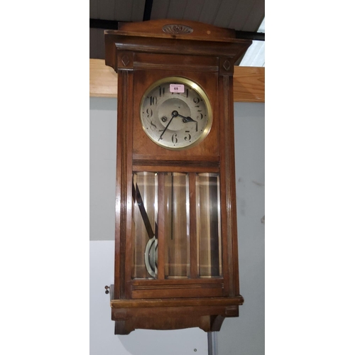 69 - An early 20th century striking wall clock in walnut case; a mantel clock with Westminster chime