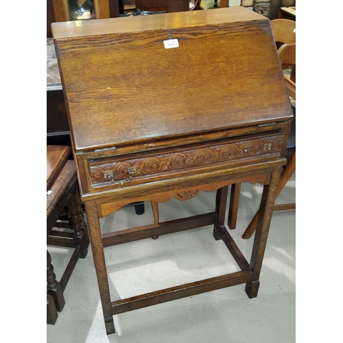 811 - A small oak bureau with fall front over single carved drawer, most fittings present and some are loo... 