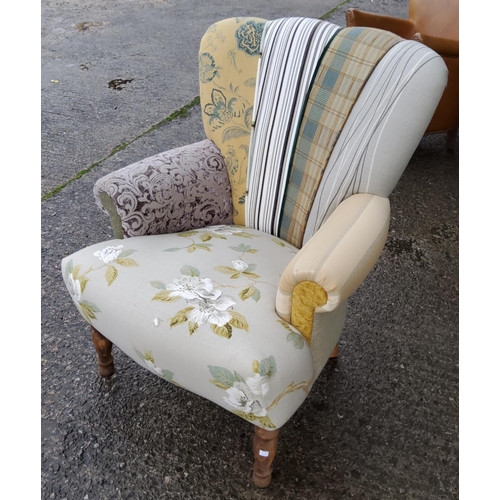 819 - A modern semi-wingback armchair upholstered in various fabrics