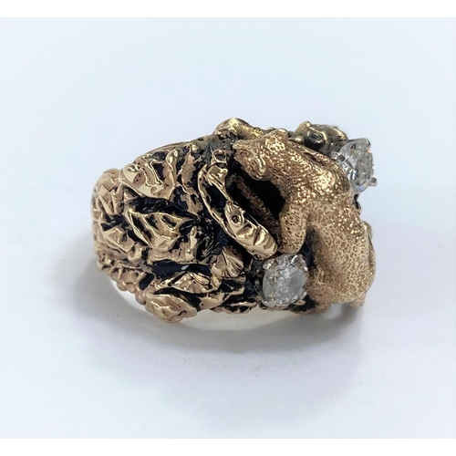 651A - A yellow metal dress ring in the form of a mountain cat climbing rocks, stamped 14k with two diamond... 