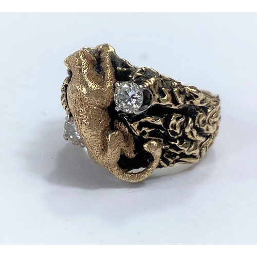 651A - A yellow metal dress ring in the form of a mountain cat climbing rocks, stamped 14k with two diamond... 